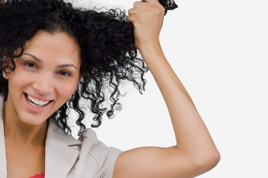 Portrait of a young woman holding her hair and smiling
