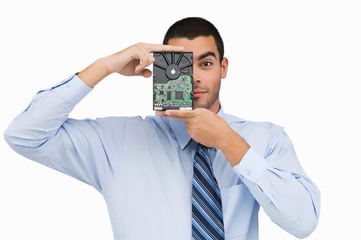 Portrait of a businessman holding a hard drive in front of his face