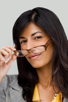 Portrait of a young woman holding a pair of eyeglasses