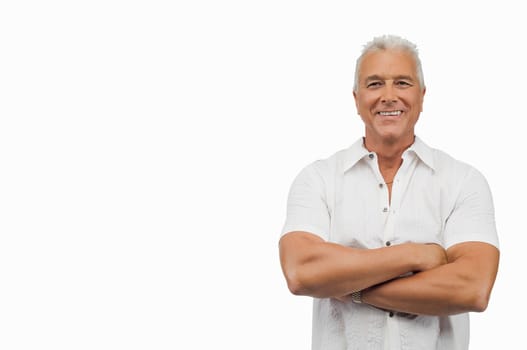 Portrait of a senior man standing with his arms crossed and smiling