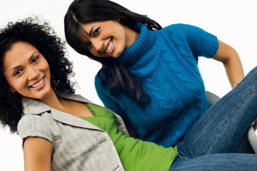 Portrait of a young woman sitting in an armchair with her friend sitting on her lap