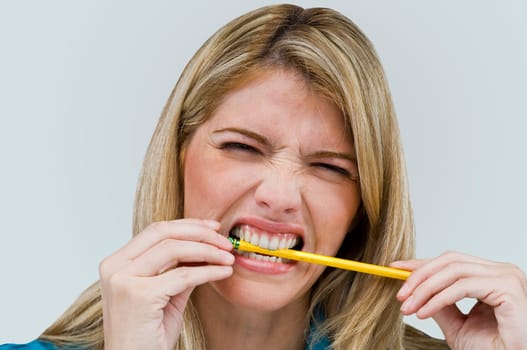 Close-up of a young woman biting a pencil