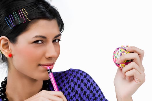 Portrait of a young woman holding rubber bands and a pen