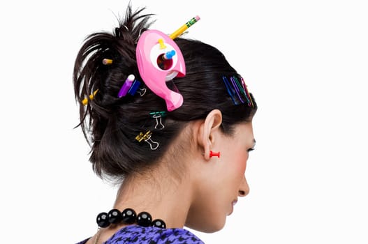 Close-up of various office supply items in a young woman's hair