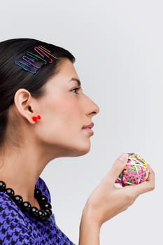Close-up of a young woman holding rubber bands and thinking