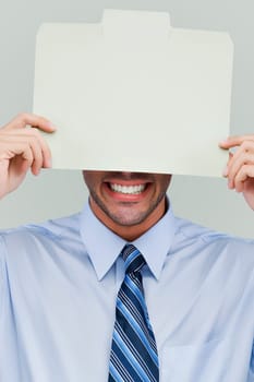 Close-up of a businessman holding a placard in front of his face