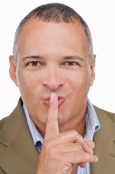 Portrait of a mature man with his finger on his lips