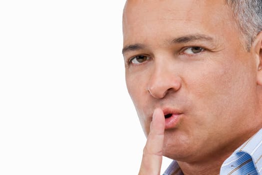 Portrait of a mature man gesturing with his finger on his lips