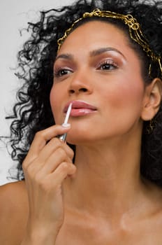 Close-up of a young woman applying lipstick