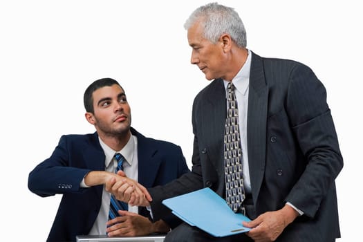 Two businessmen shaking hands and looking at each other
