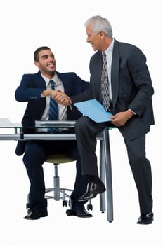 Two businessmen shaking hands and looking at each other