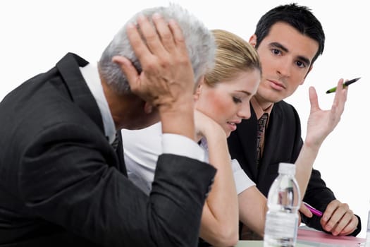 Two businessmen and a businesswoman at a meeting in a conference room