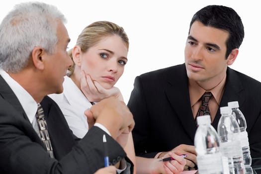 Two businessmen and a businesswoman at a meeting in a conference room