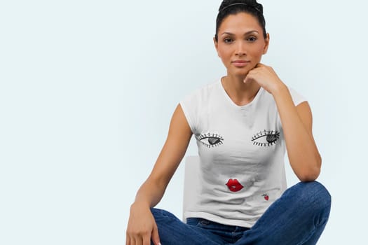 Portrait of a young woman sitting on a chair with her legs crossed