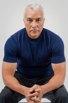 Portrait of a senior man sitting with his hands clasped