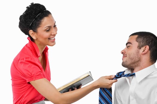Businesswoman pulling a businessman with his tie and smiling