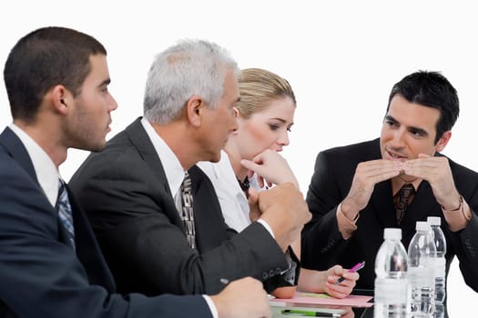 Three businessmen and a businesswoman at a meeting in a conference room