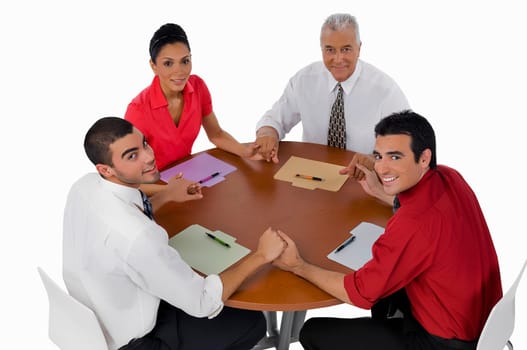 Portrait of three businessmen and a businesswoman sitting with holding their hands in a meeting