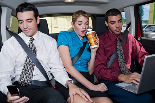 Close-up of a businesswoman sitting between two businessmen in a car