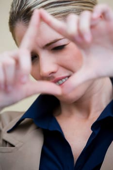 Portrait of a businesswoman looking through a finger frame