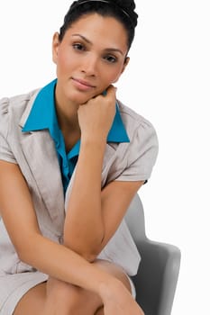 Portrait of a businesswoman sitting on a chair with her hand on her chin