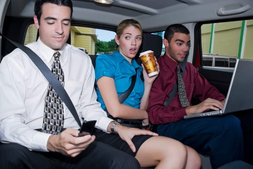 Close-up of a businesswoman sitting between two businessmen in a car