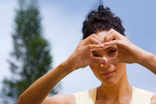 Woman making heart shape with her hands in front of her face