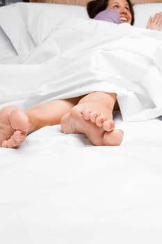 Mid adult woman lying on the bed and smiling