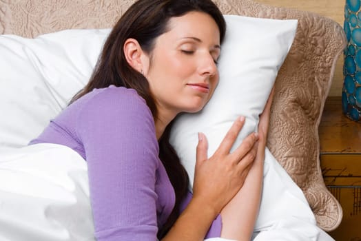 Side profile of a mid adult woman sleeping on the bed