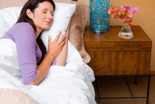 High angle view of a mid adult woman sleeping on the bed