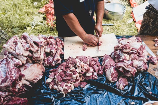 The butcher divides the meat on a wooden board. sheep's meat.