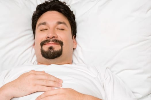 Close-up of a mid adult man sleeping on the bed