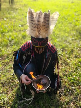 The shaman performs a ritual with the burning of grass.