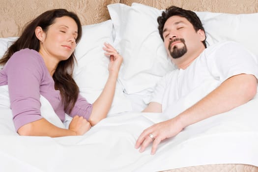 High angle view of a mid adult couple sleeping on the bed