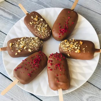 Ice cream in a cosy-ice with a wooden stick lie on a plate.