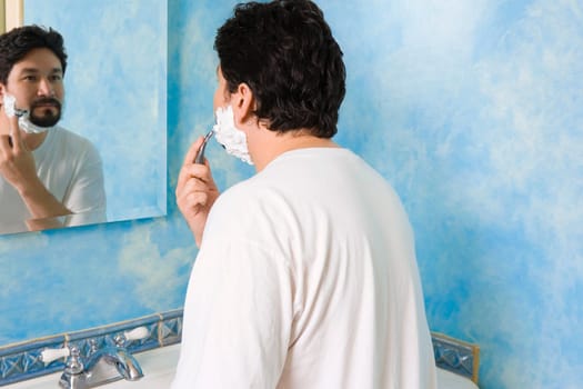 Mid adult man shaving in the bathroom