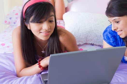 Teenage girl and a young woman looking at a laptop and smiling