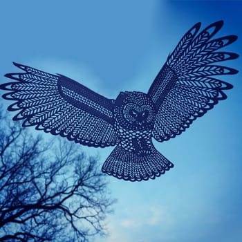 Animal figurines carved from paper in a photo of the sky. Paper-cut owl on a background of the sky.