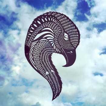 Animal figurines carved from paper in a photo of the sky. Paper-cut eagle figurine against the sky.