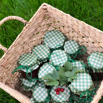 Cans of cooking in a basket. Jam in jars.