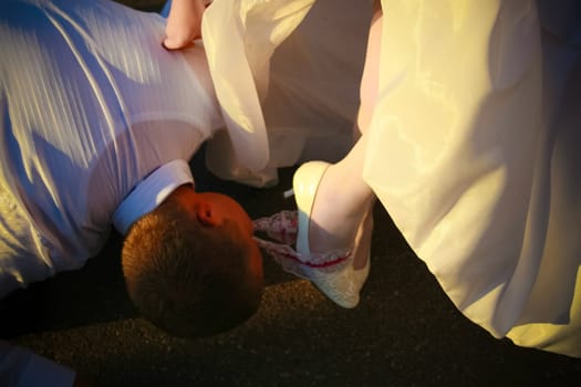 A man removes the bride's garter with his teeth. Wedding traditions.