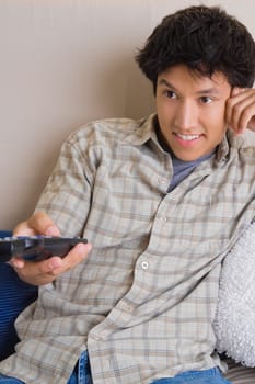 Close-up of a young man operating a remote control
