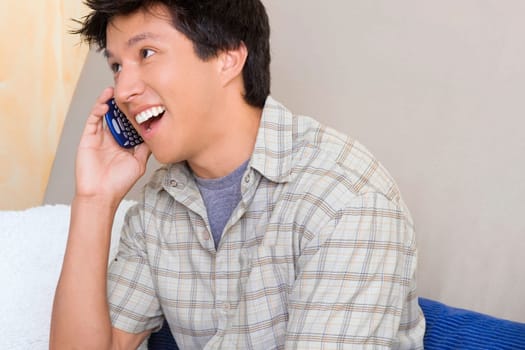 Close-up of a young man talking on a mobile phone and smiling