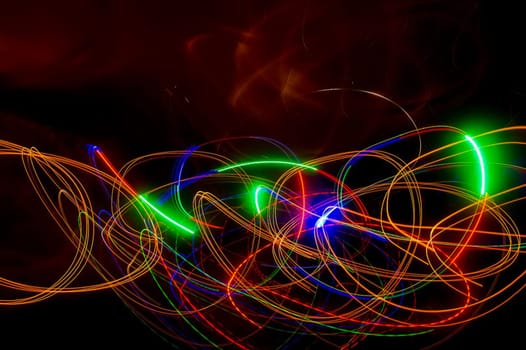Abstract colored lines on a dark background. Red and green lines.