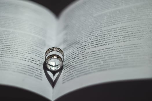 Wedding rings lie in the open book.