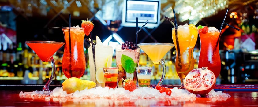 Glasses and glasses with booze and juices on the bar.