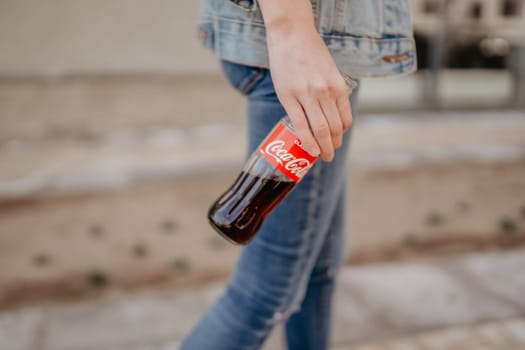Moscow, Russia - April 20, 2019: Man with a bottle of Coke in his hands.