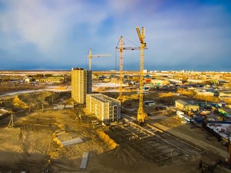 Construction of new residential buildings. Tower cranes at the construction site.