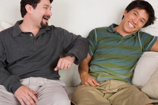 Mid adult man and his son sitting on a couch and smiling