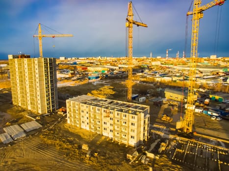 Construction of new residential buildings. Tower cranes at the construction site.